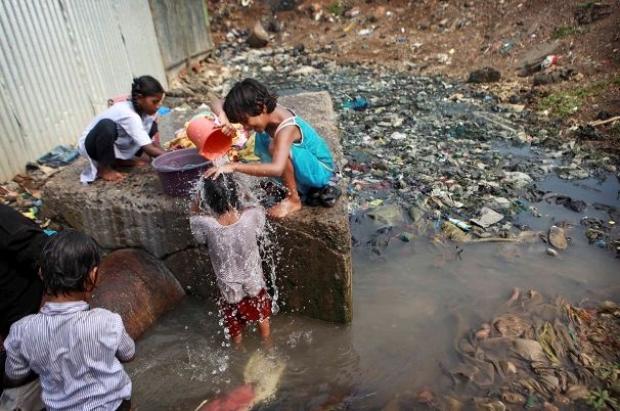 Retrato da falta de saneamento: crianças brincando em meio da água suja e lixo. Atual situação da saúde pública e saneamento básico no Brasil.